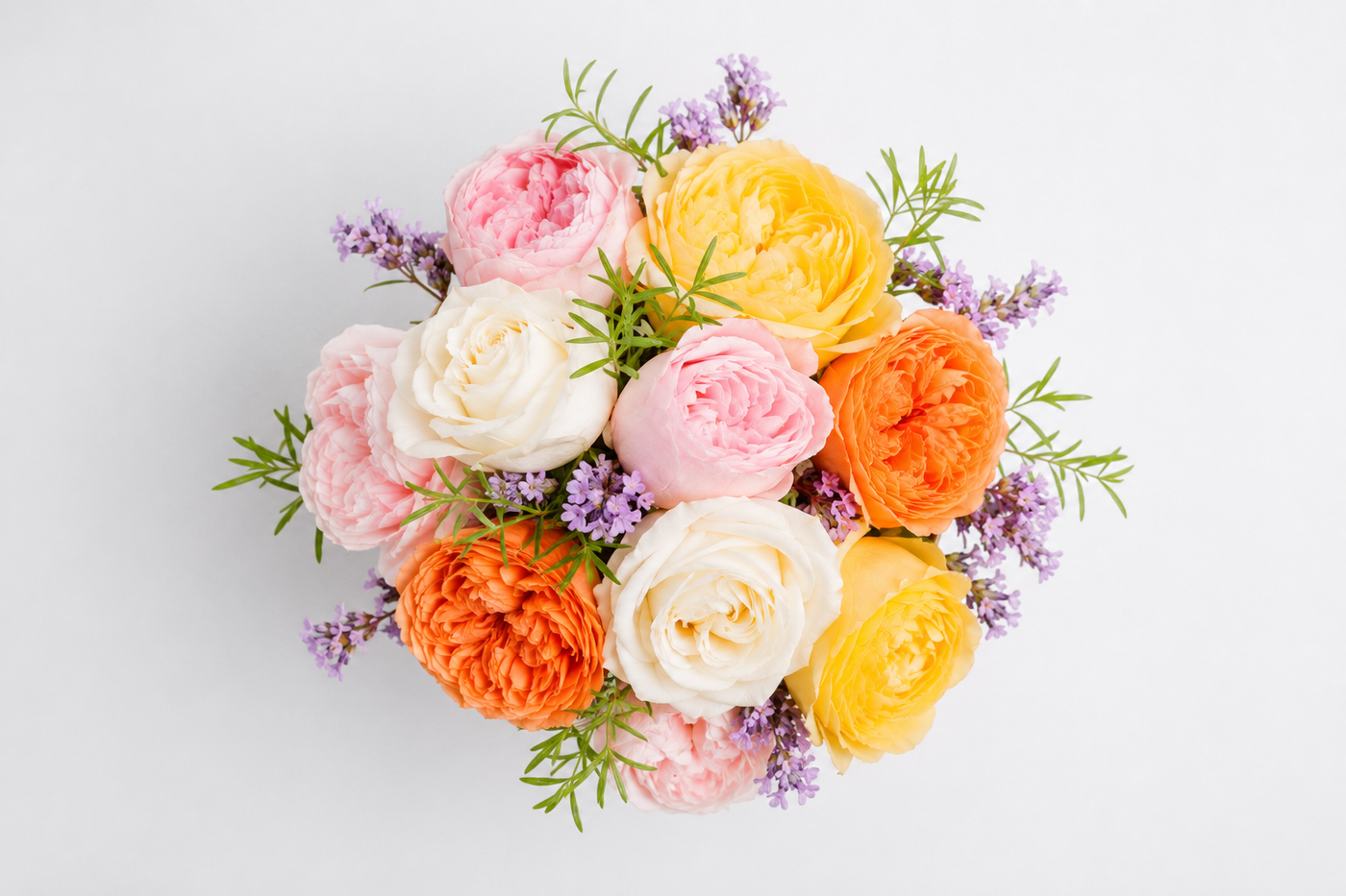 Round bouquet of pink, yellow, orange and white roses seen from above
