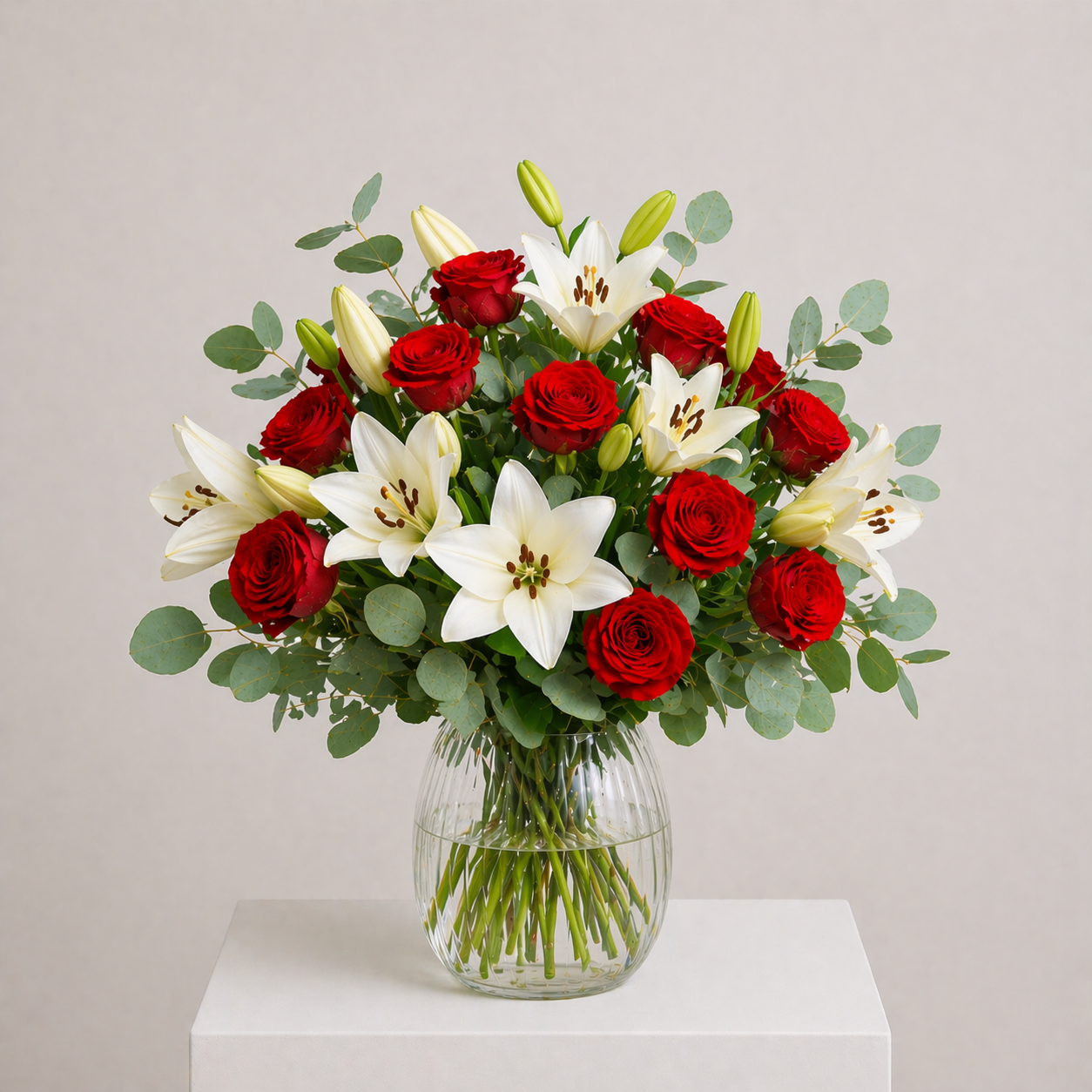 Romantischer Strauß mit roten Rosen und weißen Lilien