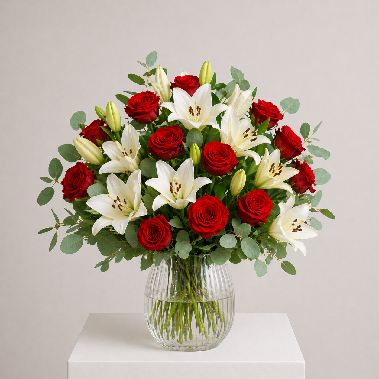 Romantischer Strauß mit roten Rosen und weißen Lilien